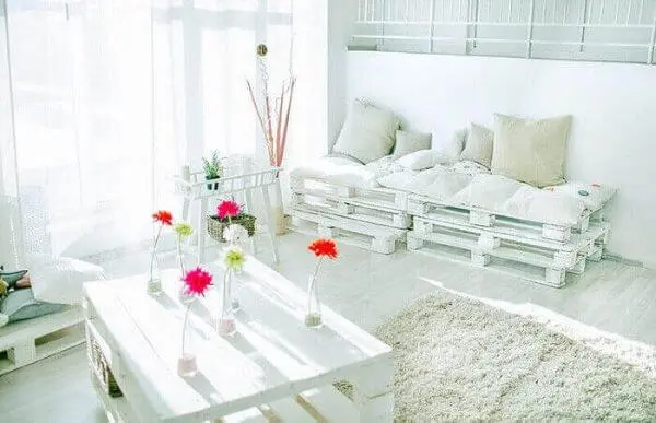 Sala de estar clean com sofá de palete branco