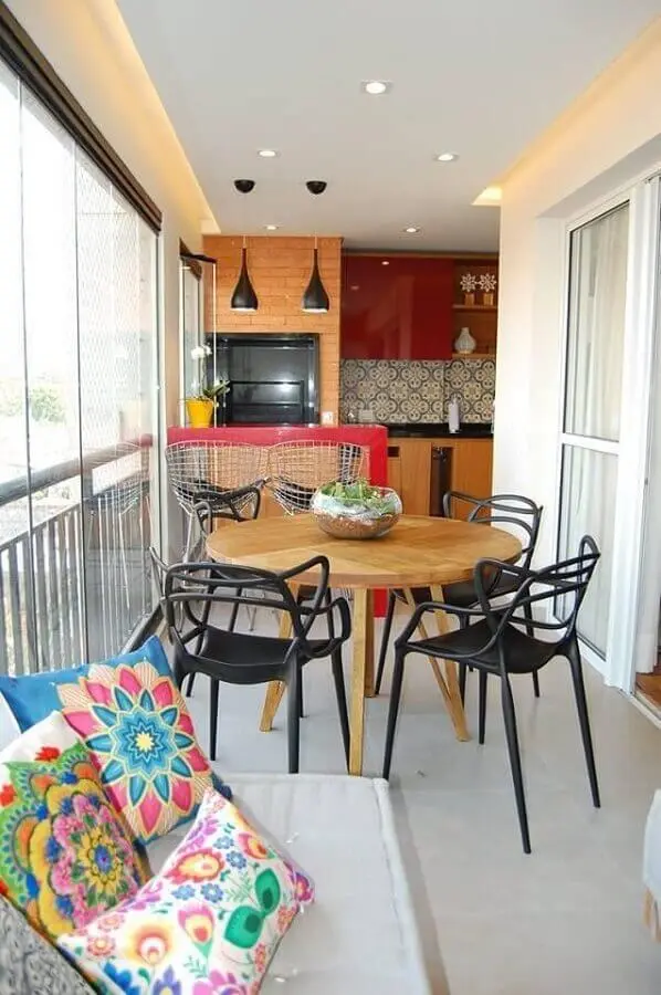 apartamento com área gourmet pequena e simples decorada com mesa de madeira redonda e bancada vermelha Foto Big Interior Design Blog