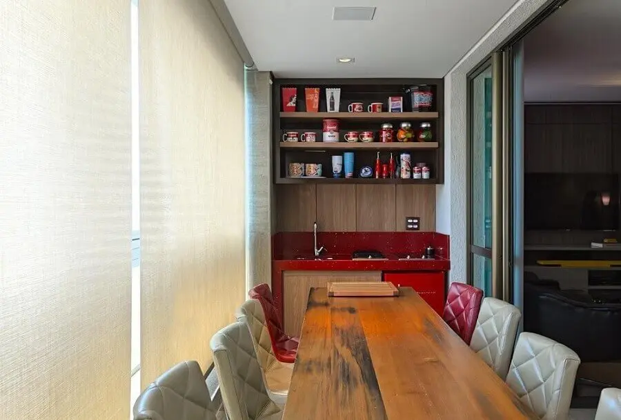 bancada vermelha e mesa de madeira para apartamento com área gourmet pequena e simples Foto Mariana Borges e Thaysa Godoy