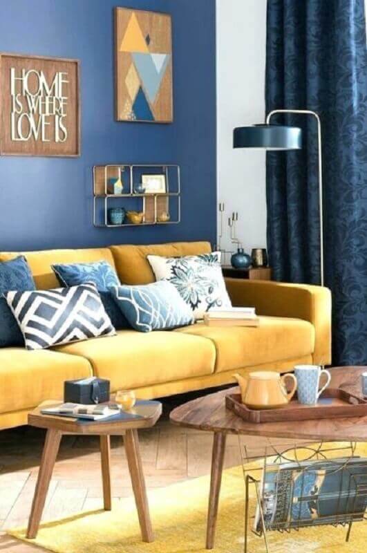 decoração de sala azul e amarela com mesa de centro de madeira Foto Archzine