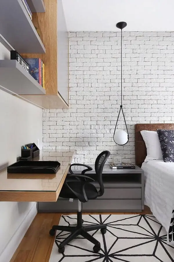 escritório em casa com bancada de madeira para quarto de casal decorado com parede de tijolinho branco Foto Zuleide Borges