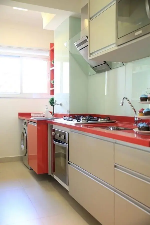 modelo de cozinha com lavanderia pequena planejada com bancada vermelha e armários bege Foto Foto Anders Widmark