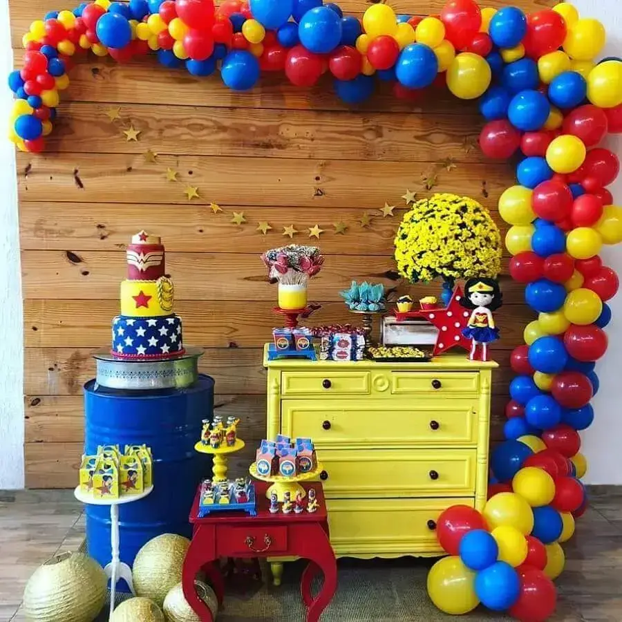 painel de madeira e móveis coloridos para decoração de festa mulher maravilha Foto A Minha Festinha