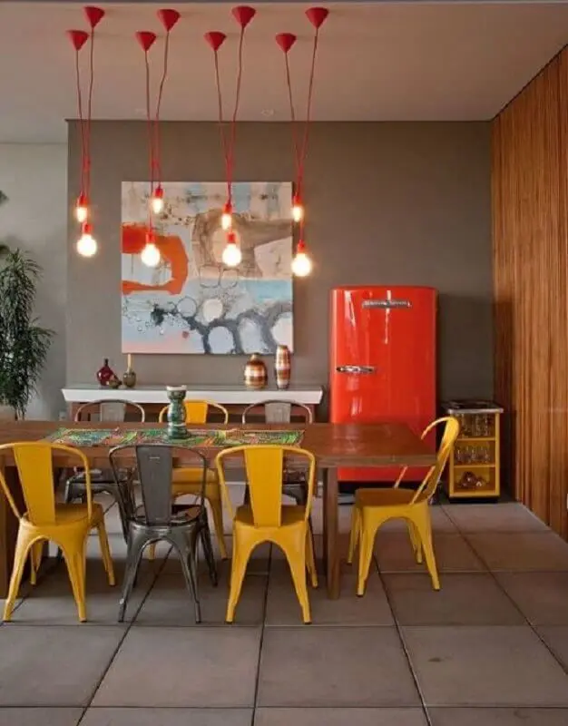 quadros abstratos coloridos para sala de jantar com mesa de madeira e pendentes vermelhos Foto Decoração e Ideias
