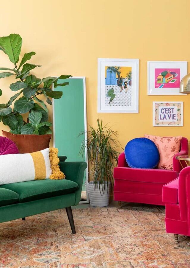 sala amarela decorada com poltronas rosa e sofá verde Foto Pinterest