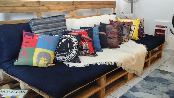 Sala com sofá de palete e almofadas estampadas