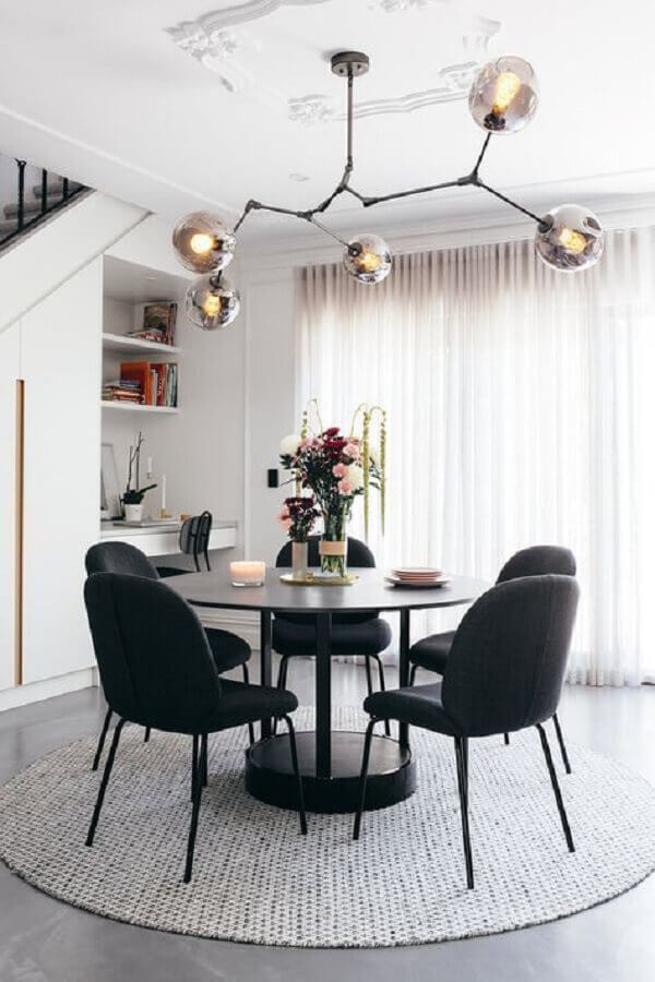 sala de jantar sofisticada e moderna com mesa redonda e cadeiras pretas Foto Arquidicas