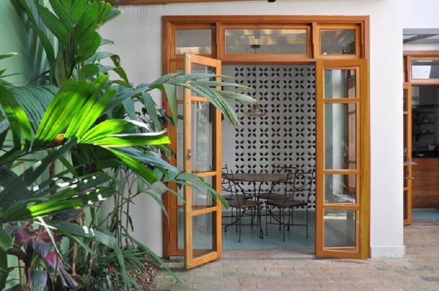 área externa decorada com porta francesa de madeira e vidro Foto Luciana Manzano