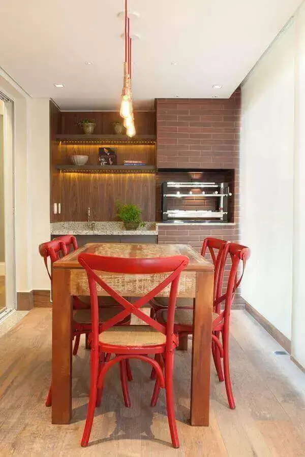 área gourmet simples com churrasqueira e cadeiras vermelhas para decoração de apartamento Foto Liliana Zenaro