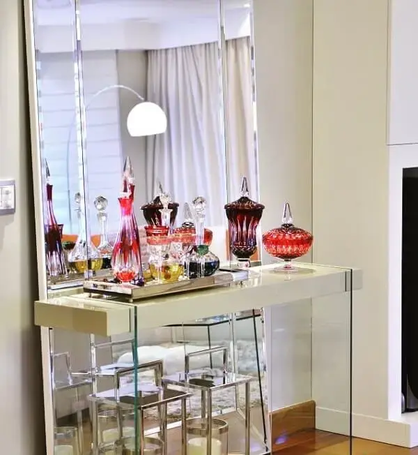 A combinação de vidro e espelho traz sofisticação para a sala de estar