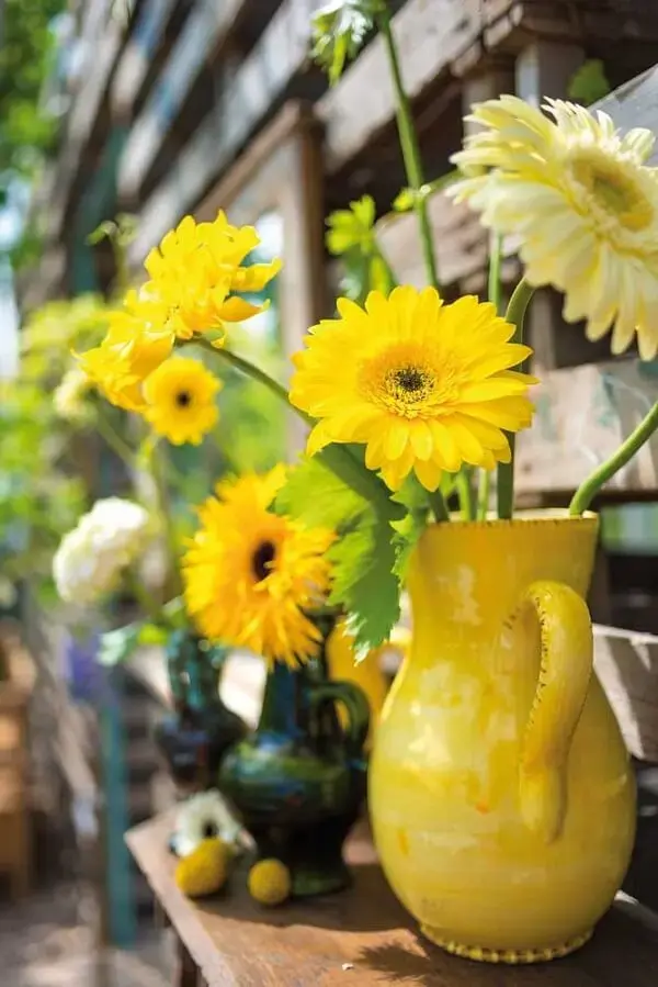 As flores amarelas de gérbera no vaso trazem aconchego para a decoração