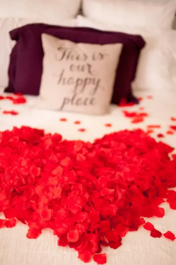 As pétalas de rosas podem formar um lindo coração sobre a cama