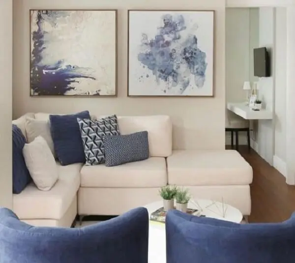 Decoração clean com sofá modular branco e almofadas em tons de azul
