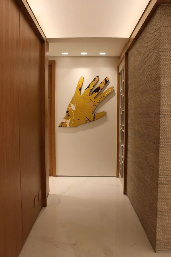 Escultura de parede feita com formato de mão amarela