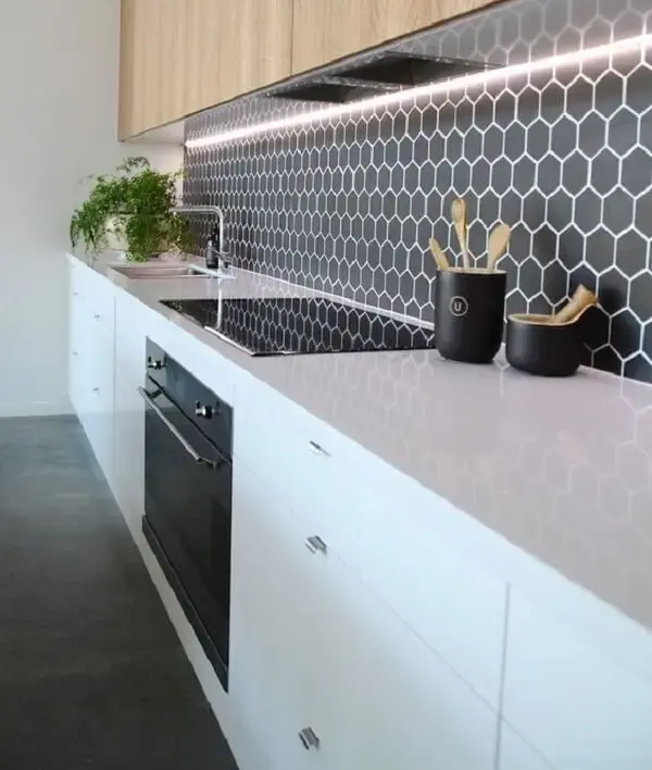 O revestimento hexagonal entre os móveis de cozinha deixou o espaço ainda mais elegante