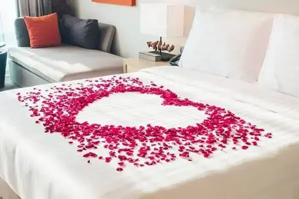Para o dia dos namorados decore a cama com pétalas de rosas