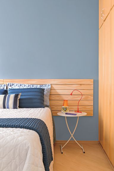 Cabeceira de madeira no quarto azul