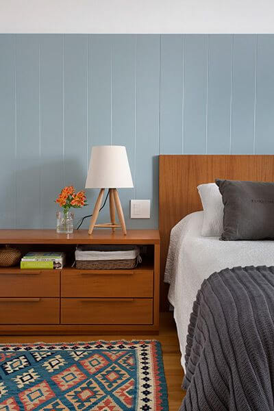 Cabeceira de madeira no quarto azul claro
