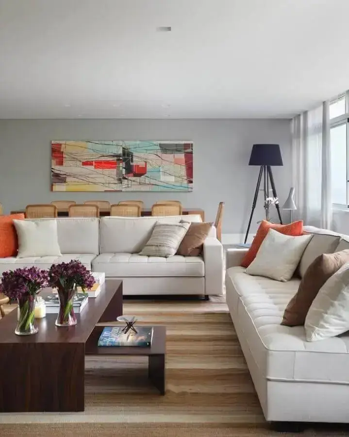 jogo de sofá branco para sala decorada com tapete listrado e quadro colorido Foto Adriana Valle Patrícia Carvalho