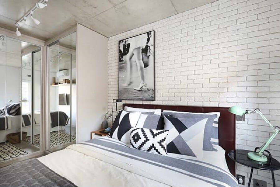 quarto branco decorado com parede de tijolinho e cabeceira casal marrom escura de couro Foto Pinterest