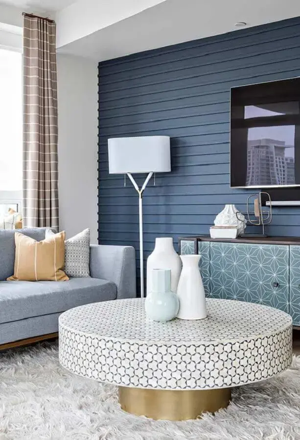 sala com parede azul decorada com sofá cinza e tapete felpudo branco Foto Kris Bristot