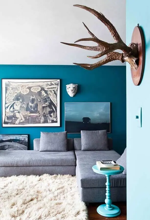 sala com parede azul decorada com tapete felpudo branco e sofá cinza Foto Casa Adore