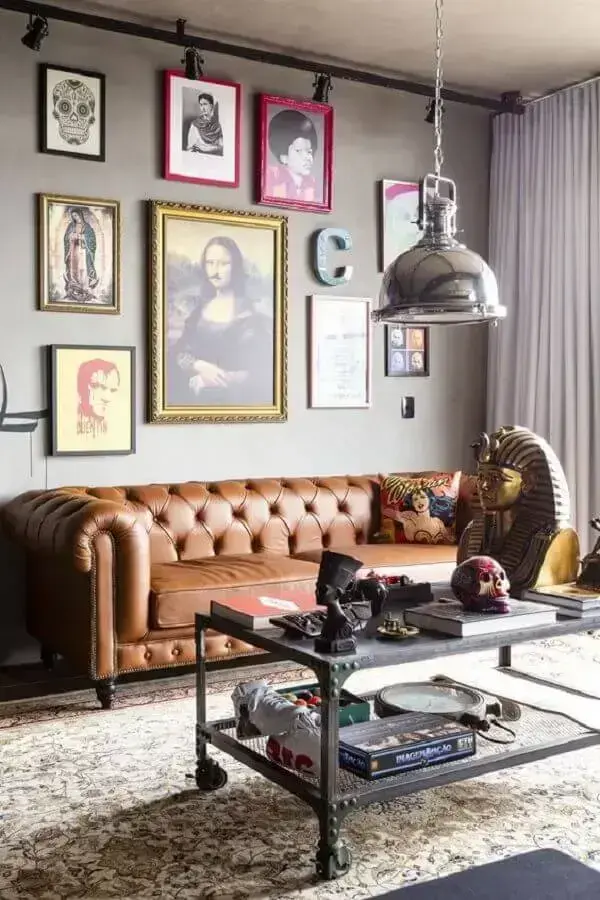 sala decorada com vários quadros e Sofá Chesterfield de couro marrom Foto Casa Vogue