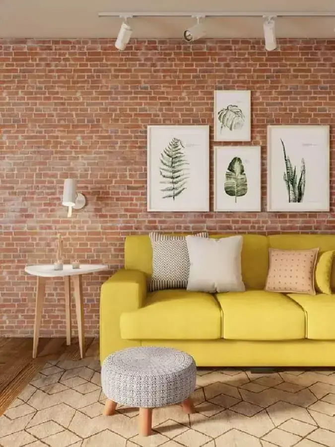 sofá amarelo para sala decorada com parede de tijolo à vista e trilho de luz branco Foto Pinterest