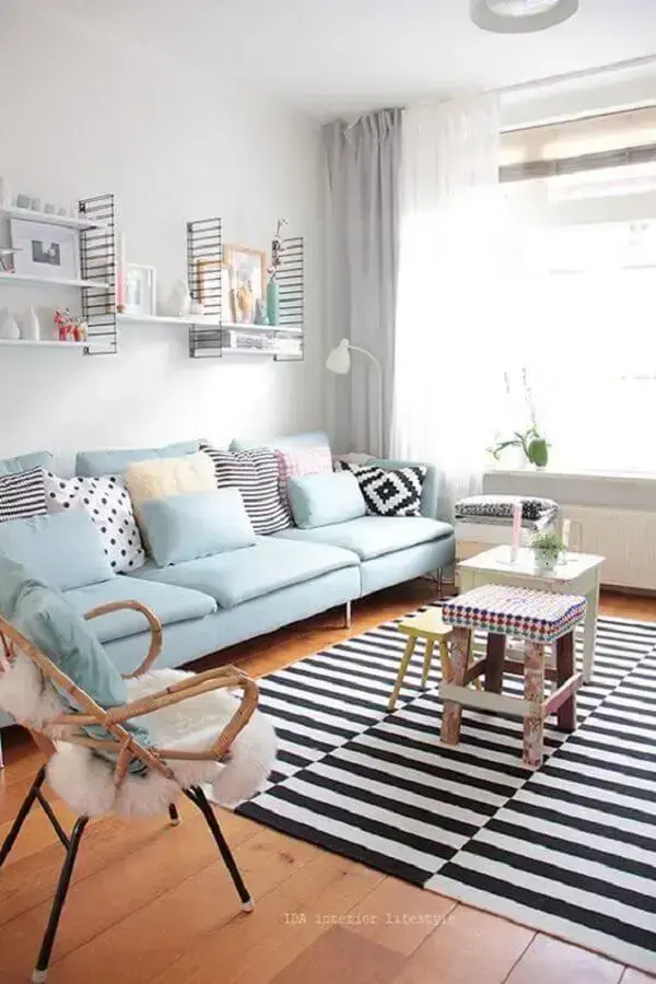 sofá azul claro para sala de estar com tapete listrado preto e branco Foto Histórias de Casa