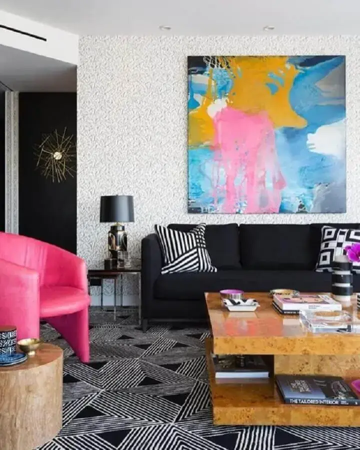 sofá preto para sala decorada com quadro colorido e poltrona rosa Foto Pinterest