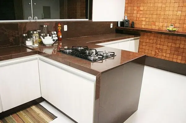 A bancada de cozinha granito café imperial conta com a presença de um cooktop na superfície