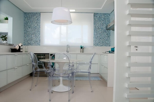 A cortina para cozinha branca se harmoniza com a parede feita em pastilhas na cor azul