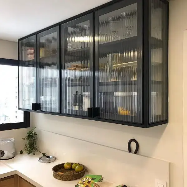 A estrutura do armário de cozinha foi feita com vidro canelado