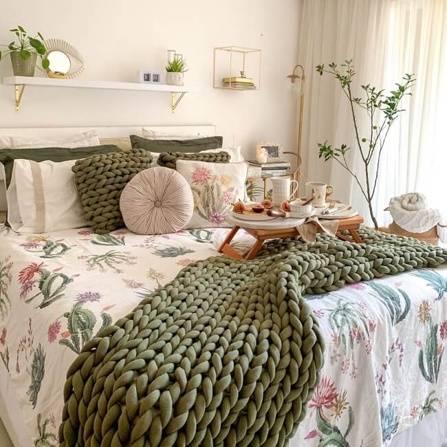 A peseira de cama verde se conecta com as almofadas da cama. Fonte: Magma