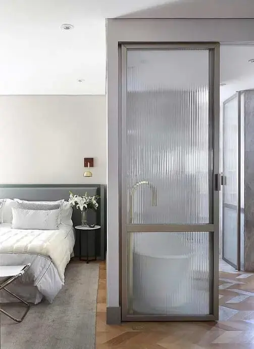 A porta do banheiro translúcida é feita com vidro canelado