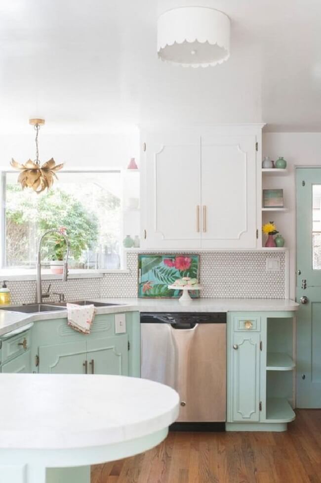 Cozinha com piso de madeira e toques de branco e verde menta nos armários