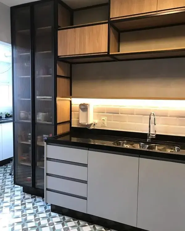 O armário planejado da cozinha conta com portas de vidro canelado