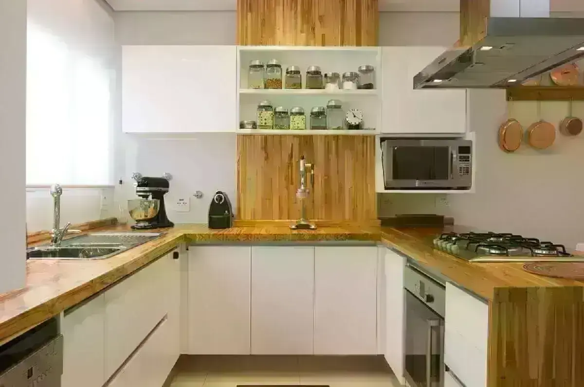 cozinha em U com bancada de madeira e armários planejados brancos Foto Webcomunica