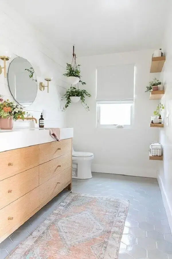 decoração com plantas no banheiro planejado com gabinete de madeira e espelho redondo Foto House Passion
