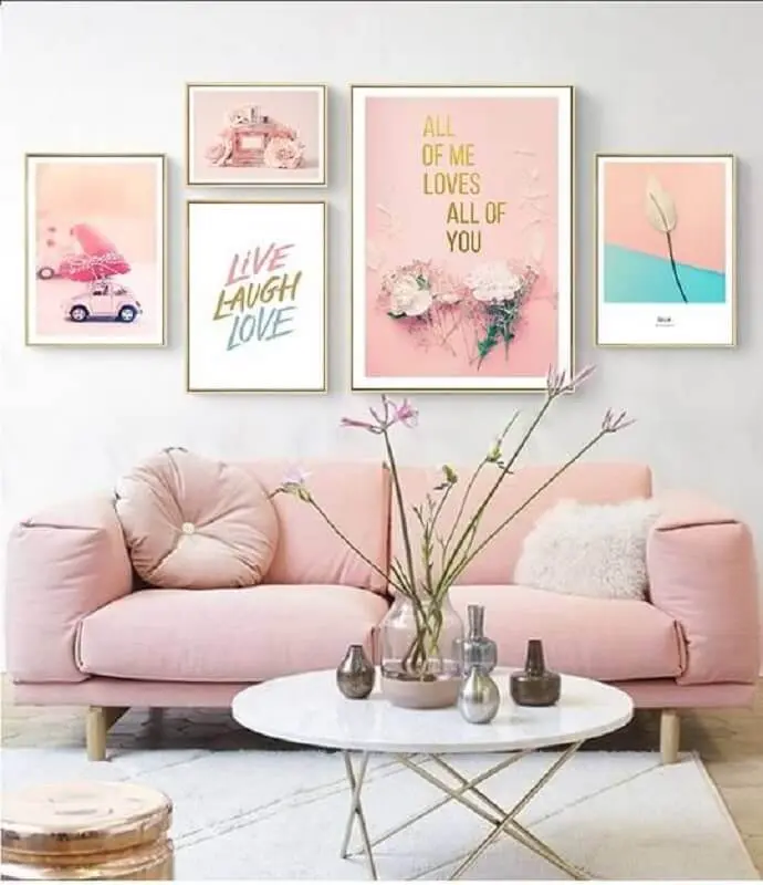 decoração para sala com sofá na cor rosa pastel e vários quadros Foto NordicWallArt