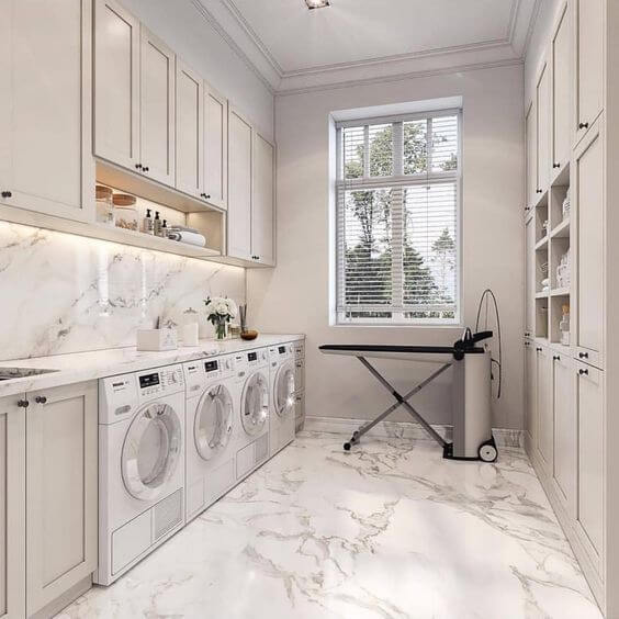 Porcelanato marmorizado na lavandeira com armários brancos