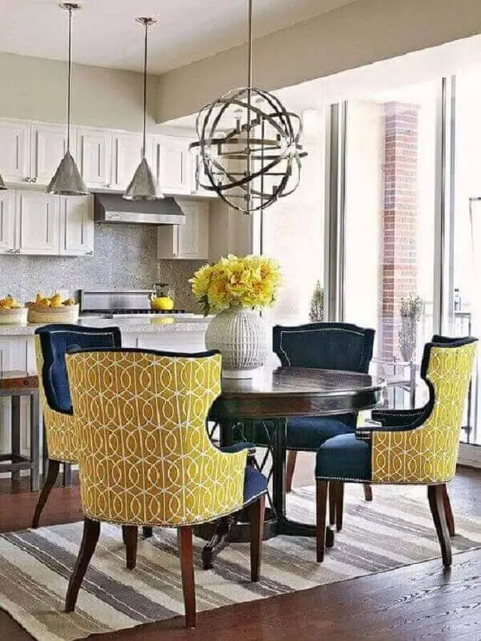 sala de jantar decorada com cadeiras clássicas coloridas e vaso de flor para mesa de jantar Foto Revista VD