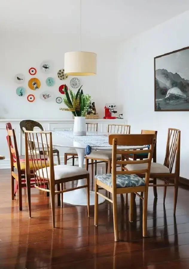 sala de jantar decorada com cadeiras de madeira e vaso para mesa de jantar redonda branca Foto Histórias de Casa
