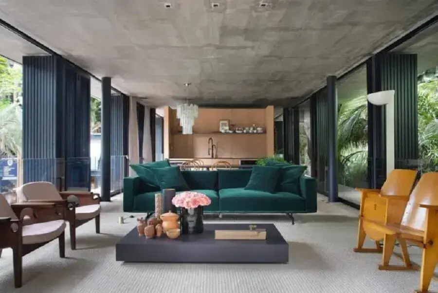 varanda ampla e moderna decorada com sofá verde esmeralda e poltronas de madeira Foto BC Arquitetos