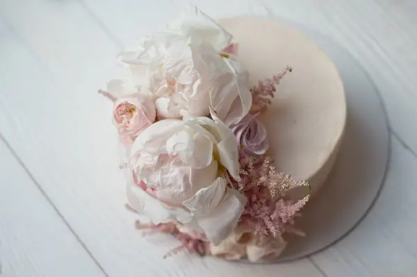 A flor de Peônia decora o topo do bolo de forma delicada e criativa