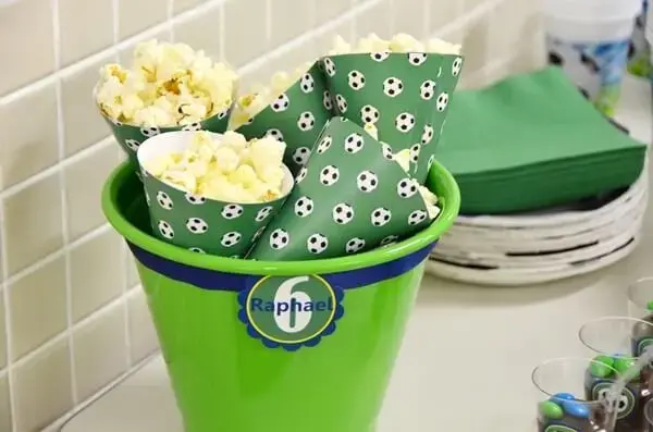 Bucket of popcorn complements simple football theme party decoration