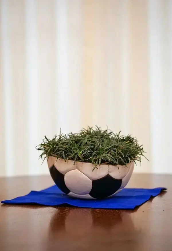 Decoração de centro de mesa com bola e grama para festa de aniversário tema futebol
