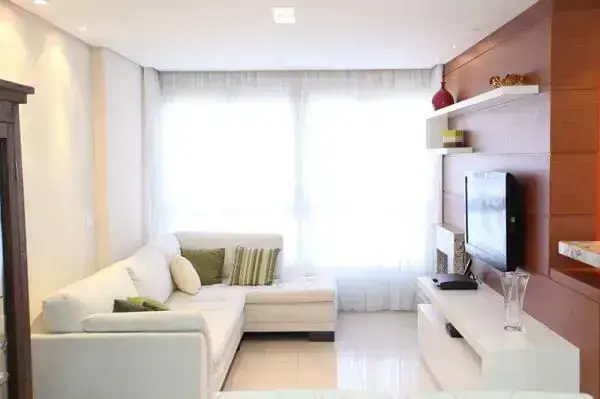 O sofá de canto branco além de otimizar o espaço, sua cor traz a sensação de amplitude no ambiente
