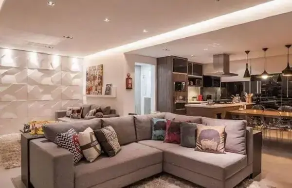 O sofá de canto cinza foi usado nessa projeto para dividir ambientes integrados