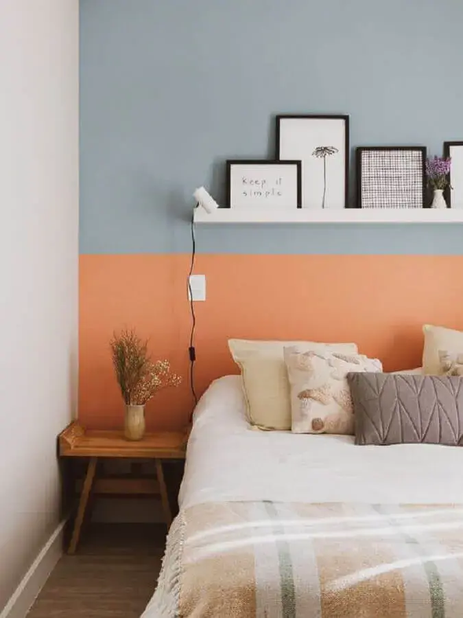 decoração de quarto com parede colorida e mesa de cabeceira pequena de madeira Foto A Casa Delas